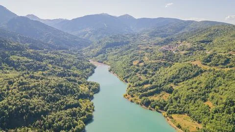High angle aerial view of calm turquoise river flowing through lush green m.. Stock Photos