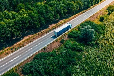 High-angle aerial view of gray cargo truck with a tarp-covered trailer driv.. Stock Photos