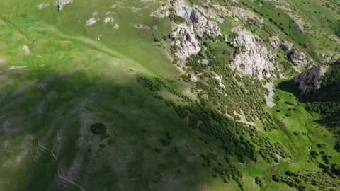 High angle aerial view of green mountain slopes and rocky ravines in Kazakhstan Видео 337206835