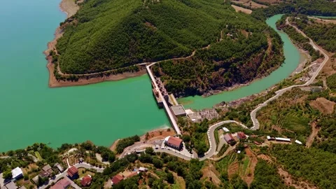 High-Angle Aerial View of Hydroelectric Dam and Winding Turquoise River Stock Footage 341395256