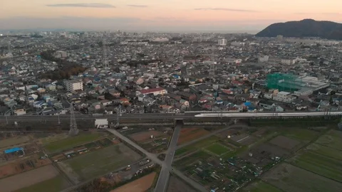 High angle aerial view, long Japanese Shinkansen Bullet train passes small Stock Footage 100446884