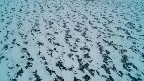 High Angle Aerial View of Mottled Snow Drifts and Ice Patches on Frozen Lake Stock Photos