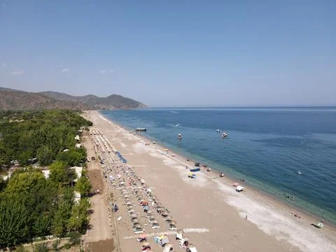 High-angle aerial view of organized pebble beach with sunbeds and umbrellas in C Foto stock