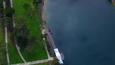 High angle aerial view of a person walking on a lakeside pier Stock Footage 339376845