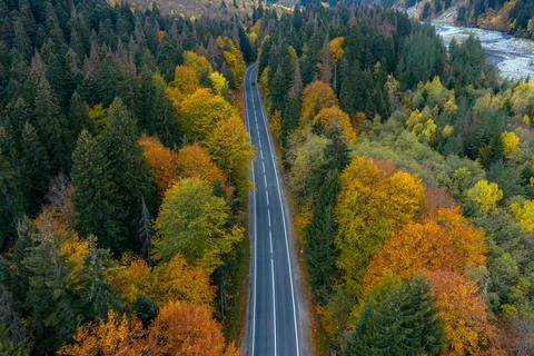 High angle aerial view of river and road running through forest and mountainous Stock Photos