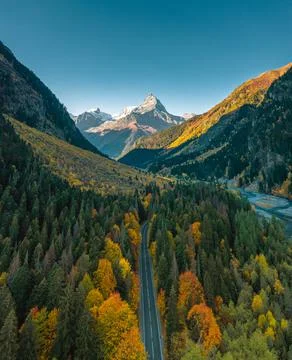 High angle aerial view of river and road running through forest and mountainous Stock Photos