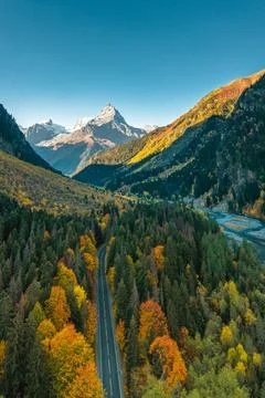 High angle aerial view of river and road running through forest and mountainous Stock Photos