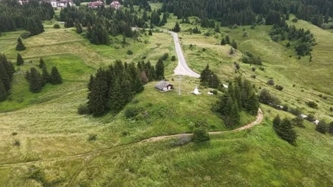 High angle aerial view of a small mountain chapel with cross and winding road Video stock 342230911
