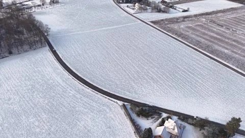 A high angle aerial view of a snow blanketed rural landscape. A small cluster Stock Footage 329448740