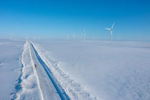 High-angle aerial view of a snow-cleared road stretching through a vast white Stock Photos