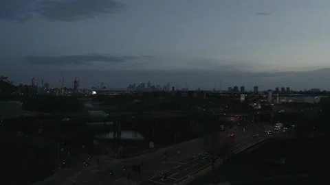 HIGH ANGLE BACKWARDS NIGHT CITY REVEAL WITH MOVING CARS Stock Footage 149847994