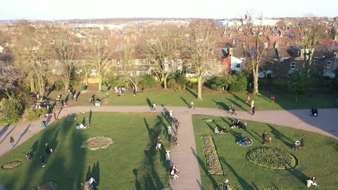 HIGH ANGLE  BACKWARDS REVEAL OF A BUSY EUROPEAN PARK IN WINTER SUNSET Stock Footage 150136347