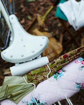 High angle close up of bicycle seat with umbrella and quilt on bicycle rack Stock Photos