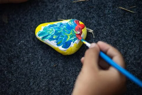High Angle Close Up of Child Hand Applying Blue and Red Paint with Brush on.. Stock Photos