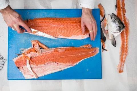 High angle close up of fishmonger standing at a table, cutting and filleting 写真素材