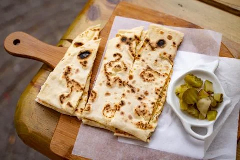 High angle close-up of flatbread with pickles served on table at sidewalk cafe Stock Photos