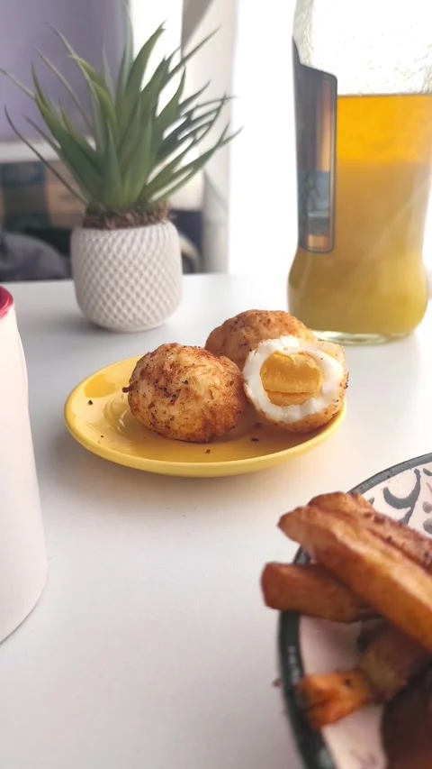High-angle close-up of a hand picking up one crispy fried egg from a yellow Vídeos de archivo 334700178