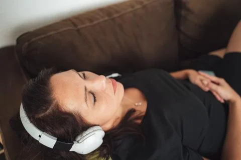 High angle close up of relaxed mid adult woman listening music through Stock Photos