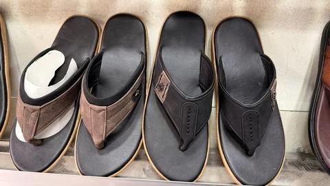 A high-angle, close-up of a row of assorted flip-flops on display, showcasing Foto stock
