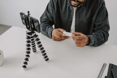 High angle close up shot black man vlogger using phone camera on tripod review Stock Photos
