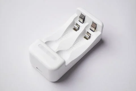 High-angle, close-up shot of an empty white universal battery charger with .. Stock Photos