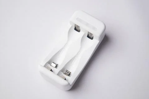 High-angle, close-up shot of an empty white universal battery charger with .. Stock Photos