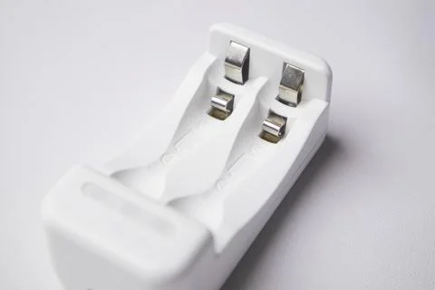 High-angle, close-up shot of an empty white universal battery charger with .. Stock Photos