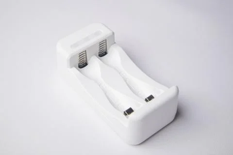 High-angle, close-up shot of an empty white universal battery charger with .. Stock Photos