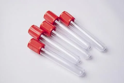 A high-angle, close-up shot of four empty medical blood collection tubes wi.. Stock Photos