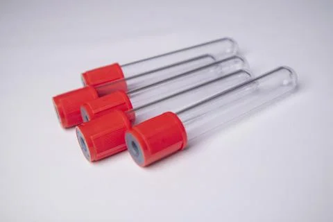 High-angle, close-up shot of four empty medical blood collection tubes with.. Stock Photos
