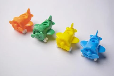 High-angle, close-up shot of four colorful plastic toy airplanes (orange, g.. Stock Photos