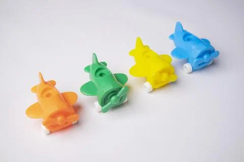 High-angle, close-up shot of four colorful plastic toy airplanes (orange, g.. Stock Photos