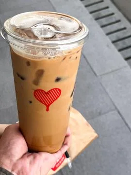 A high-angle, close-up shot of a hand holding a large iced caffe latte Stock Photos