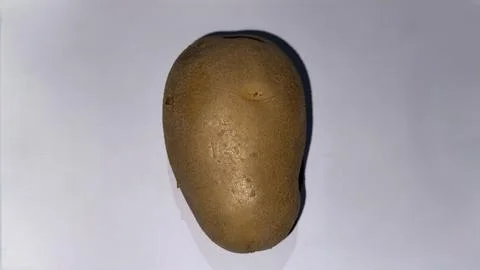 A high-angle, close-up shot shows a solitary brown potato positioned horizont Fotos Stock