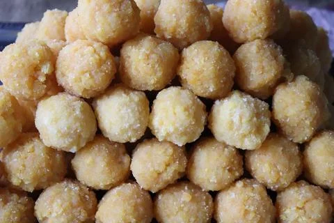 High-angle close-up showcases a stack of round, yellow Besan Laddu, a popular Stockfoto's