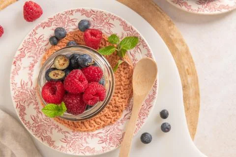 A high-angle close-up shows a glass jar of overnight oats with chia seeds t.. Foto stock