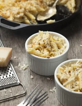 High angle close up of two ramekins and a dish with mac and cheese, cheese .. Stock Photos