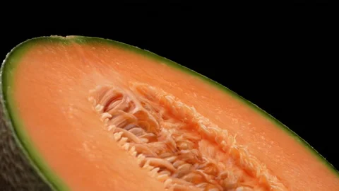 High angle closeup view of cantaloupe melon half rotating. Isolated. Black Stock Footage 169852186