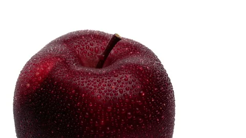 High angle closeup view of a red apple with water drops rotating. Isolated on Stock Footage 169754980