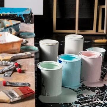 High angle of colored paint cans in studio with frames and brush Photo Stock Photos