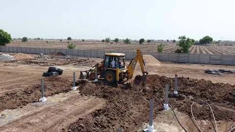 High-angle commercial development shot capturing an active yellow backhoe Stock Footage 337045317