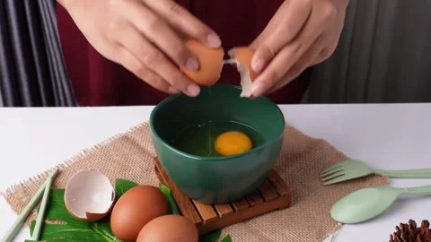 High Angle of Cracking Two Eggs and Pouring Into Green Bowl 库存影片 266763656