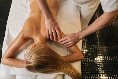High-angle cropped shot view of professional male master doing back massage to Stock Photos