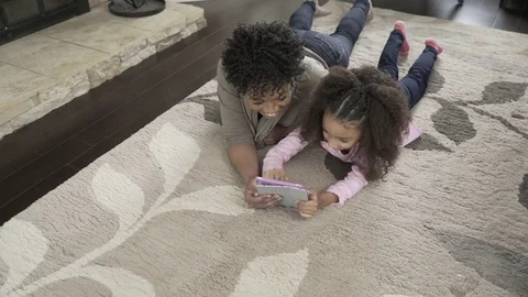 High angle dolly shot of mother and daughter using tablet computer while lying Stock Footage
