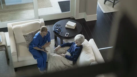 High angle dolly shot of senior woman and home caregiver using tablet computer Stock-Footage 96230766