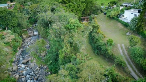 High-Angle Drift Over Rocky Creek, Meadow Lane and Hillside Homes Video stock 316794626