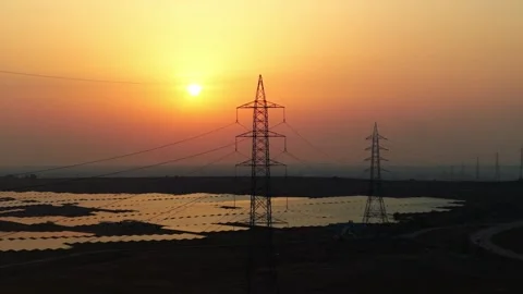 High-angle-drone-ascending-solar-farm-transmission-tower-sunset Stock Footage 342804286