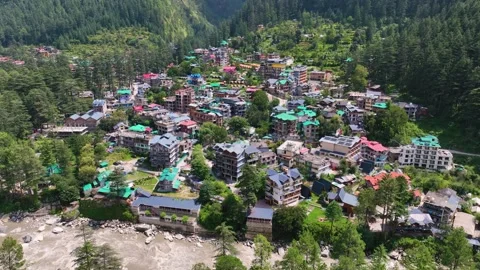 High angle drone reveal of the sprawling alpine town of Kasol nestled deepl.. Video stock 345274832
