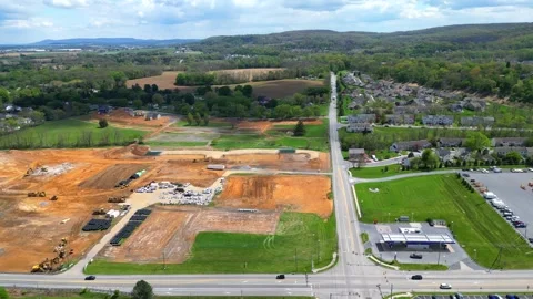 A high-angle drone shot captures active land clearing and site preparation Video stock 333940289