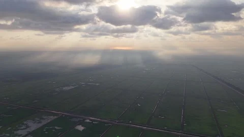 High-angle drone shot captures dramatic cloud cover over vast green fields Vidéo 337540948